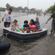 People use an air mattress to float down a flooded street as they evacuate their homes after the area was inundated with flooding from Hurricane Harvey on Aug. 27, 2017, in Houston. (Joe Raedle/Getty Images)